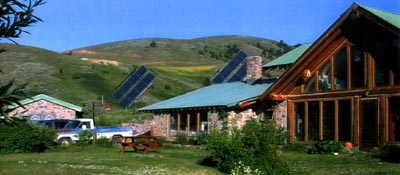 Sustainable stone and log home with solar panels.