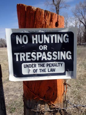 No Hunting or Trespassing, under penalty of the law sign.