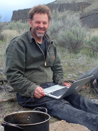 Tom Elpel typing outdoors.